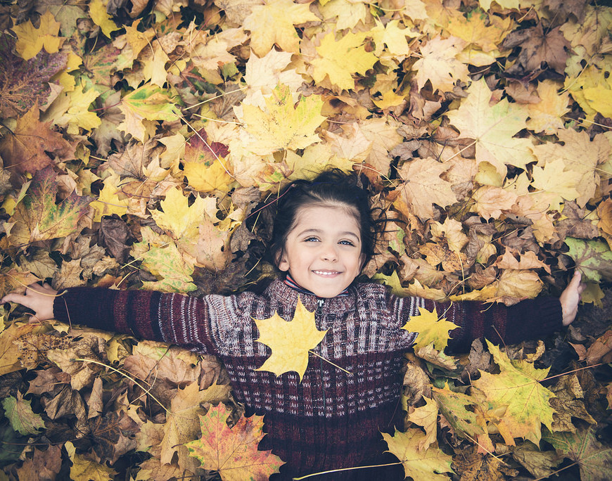 Autumn Garden: Boy playing in leaves