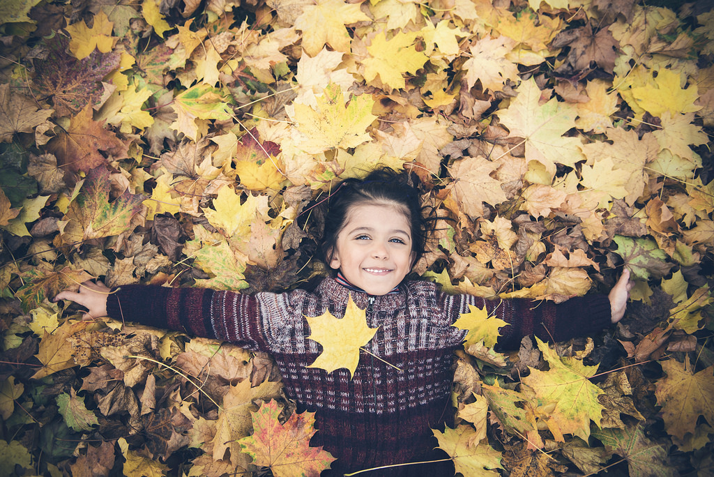 Autumn Garden: Boy playing in leaves